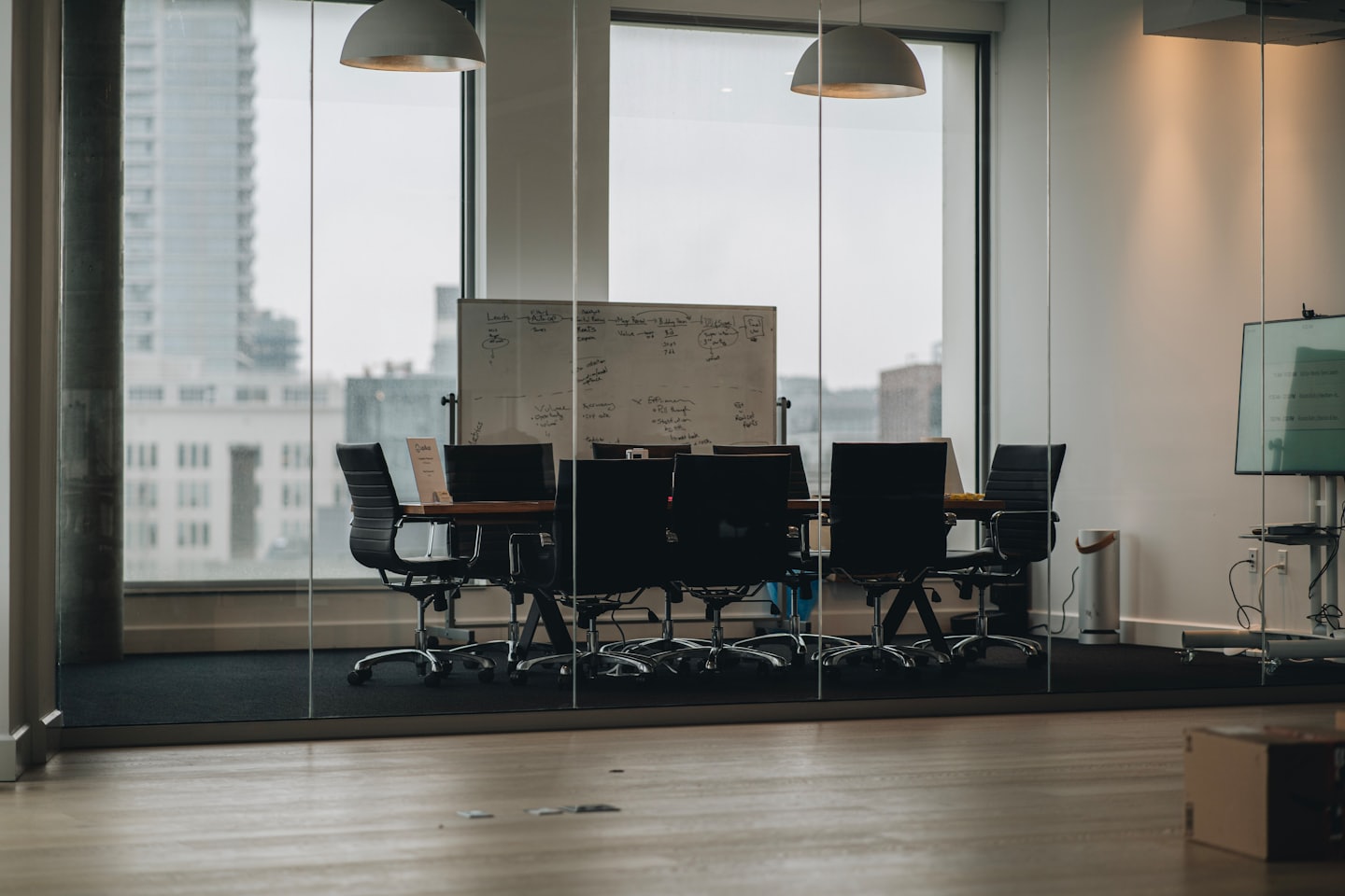 Empty conference room with a large wooden table and city view.